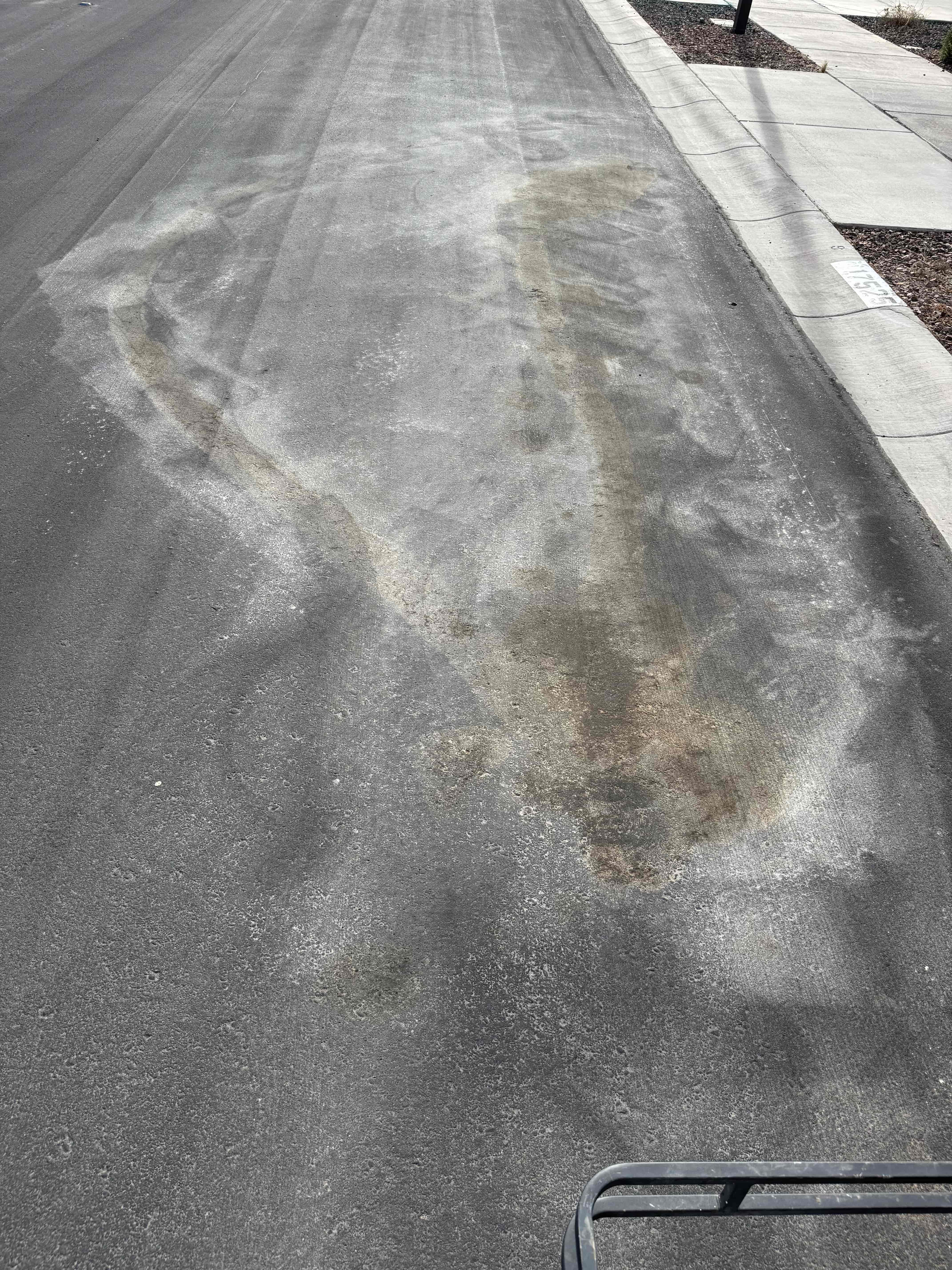 Transmission oil stain on asphalt before cleaning