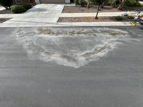Oil stain on residential asphalt before cleaning